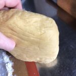 my hand holding the chilled dough to show what it should look like after being chilled