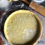 a crostata dough in the tart pan that's been pricked with a fork