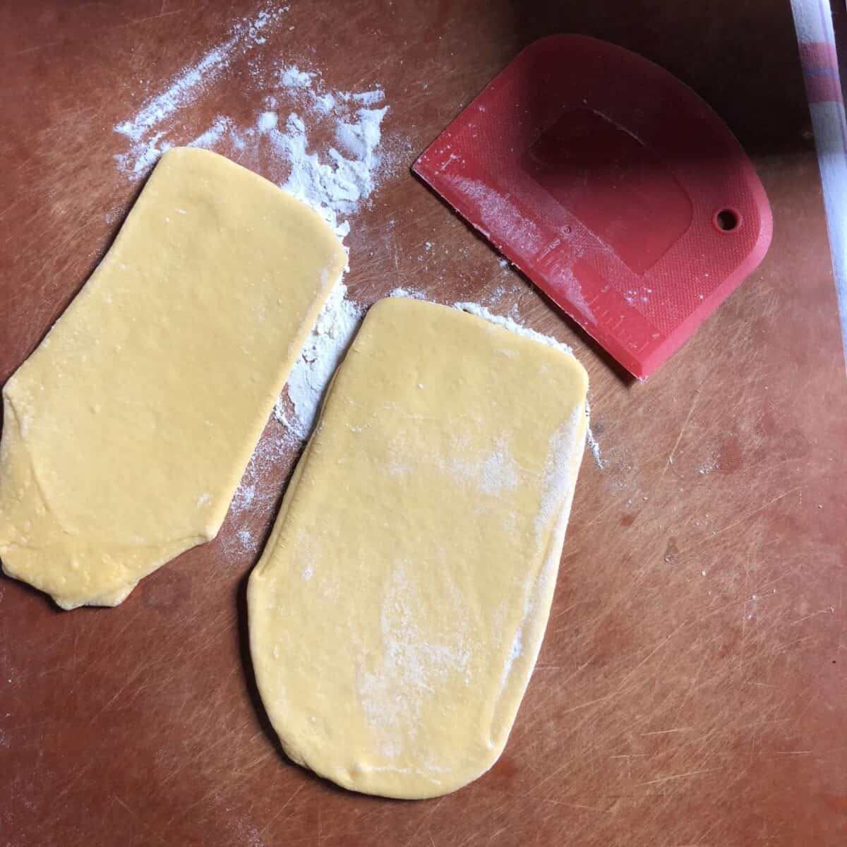 dough cut into 2 equal pieces (one rests under a towel while the other gets rolled and cut into desired pasta shapes)