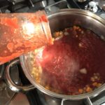 pouring La Giara organic Italian Pera d'Abruzzo tomato passata into the sauteed vegetables