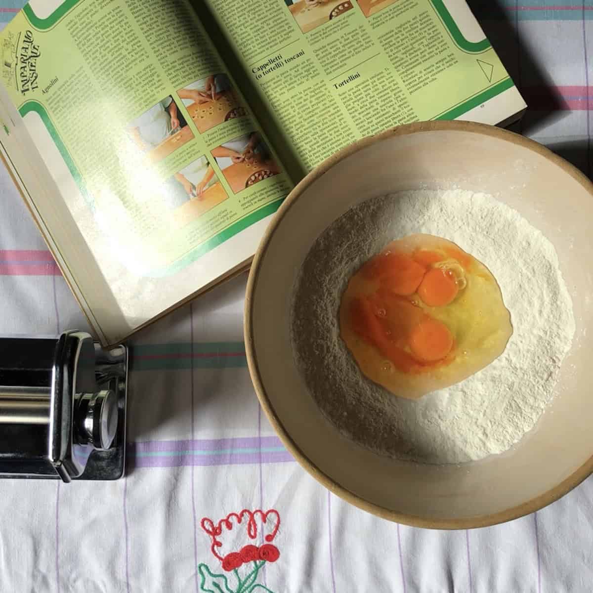 Eggs added to a well in the semolina and 00 flour mixture in a mixing bowl, 00 flour and semolina pasta recipe first step.