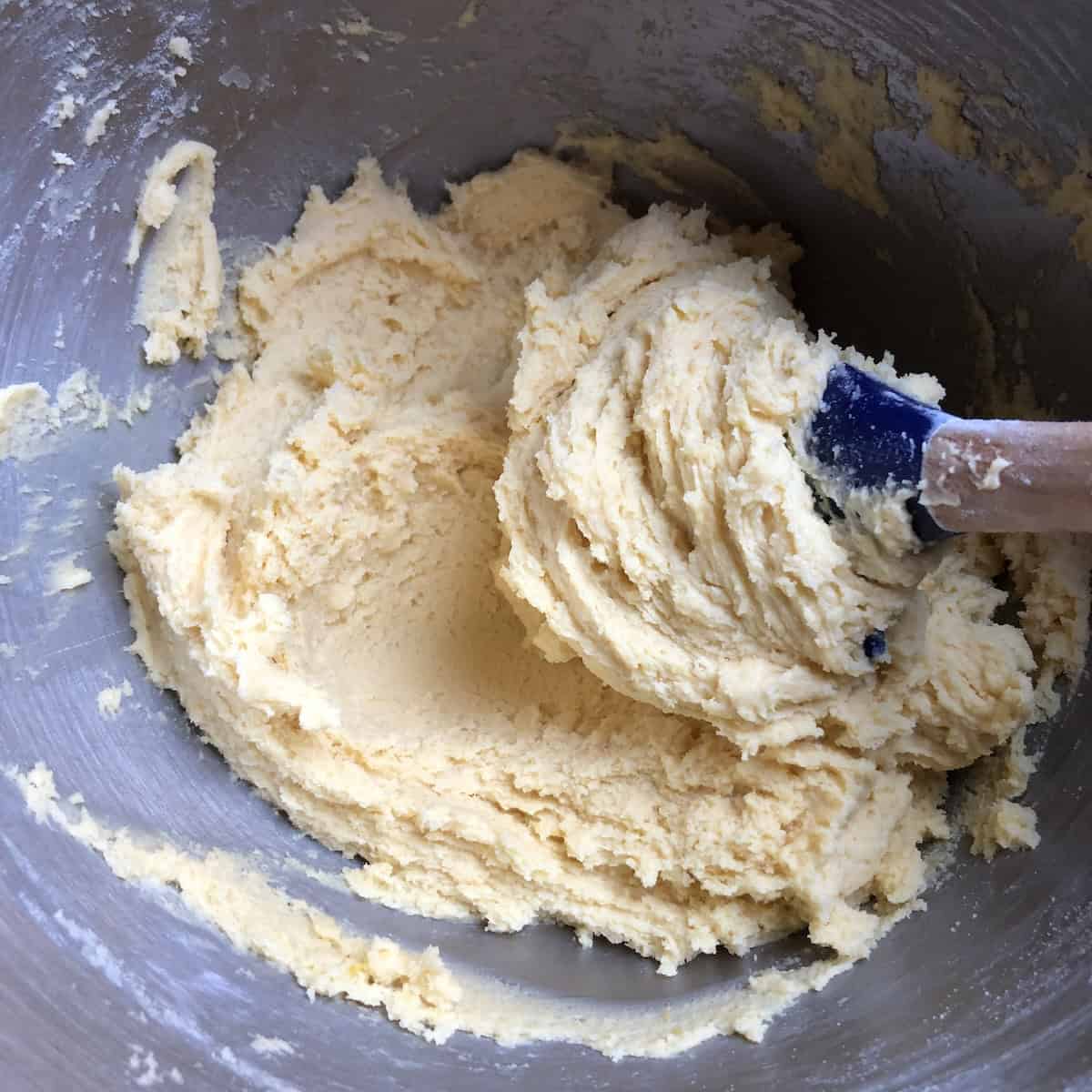 Pasta frolla dough properly combined with no flour streaks remaining, ready to form into a disc and chill, showing correct texture for Italian crostata shortcrust pastry before refrigerating.