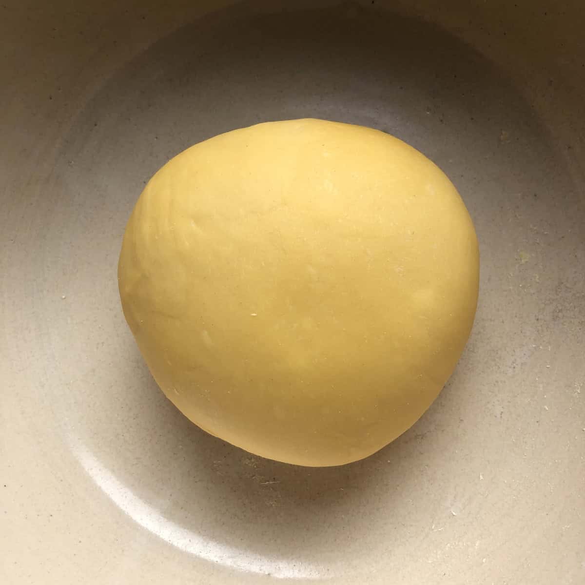 A perfectly kneaded semolina and 00 flour pasta dough ball with a smooth surface ready to cover and rest, 00 flour and semolina pasta recipe.