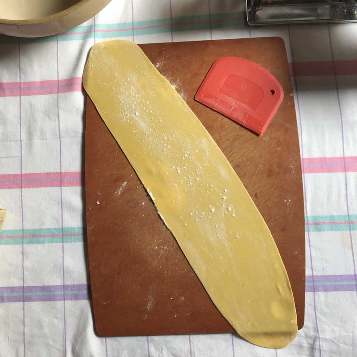 A perfectly thin rolled sheet of semolina and 00 flour pasta ready to be cut into shapes, scratch pasta recipe half semolina and half 00 flour.