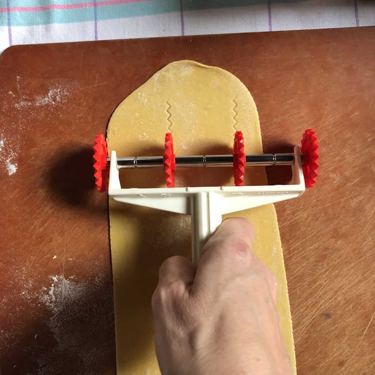 Using a pasta bike to cut ribbons of semolina and 00 flour pasta dough with reginelle zigzag edges, semolina and 00 flour pasta recipe cut into fresh pasta shapes.