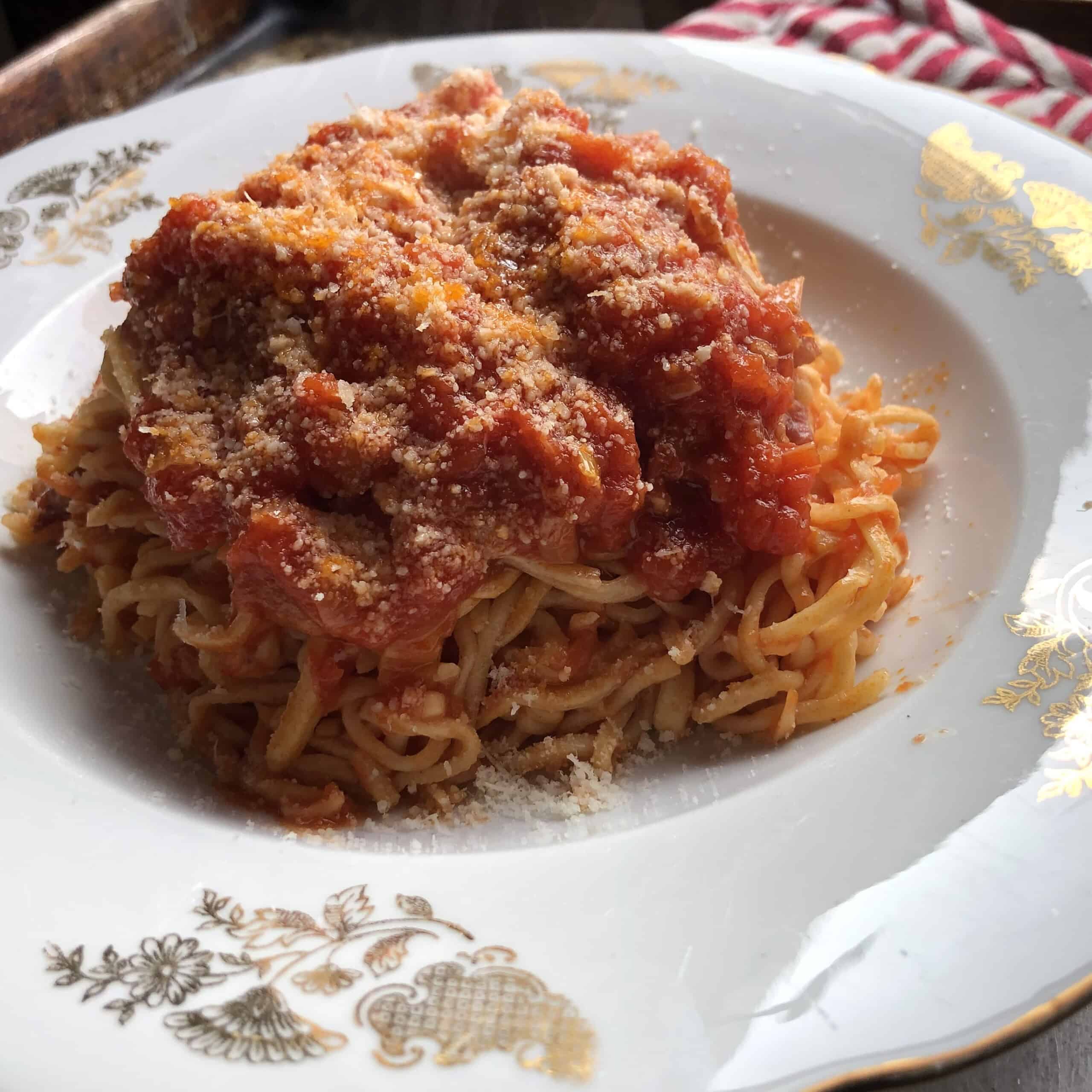 A plate of homemade spaghetti alla chitarra pasta in a vintage Italian pasta bowl ready to eat. 
