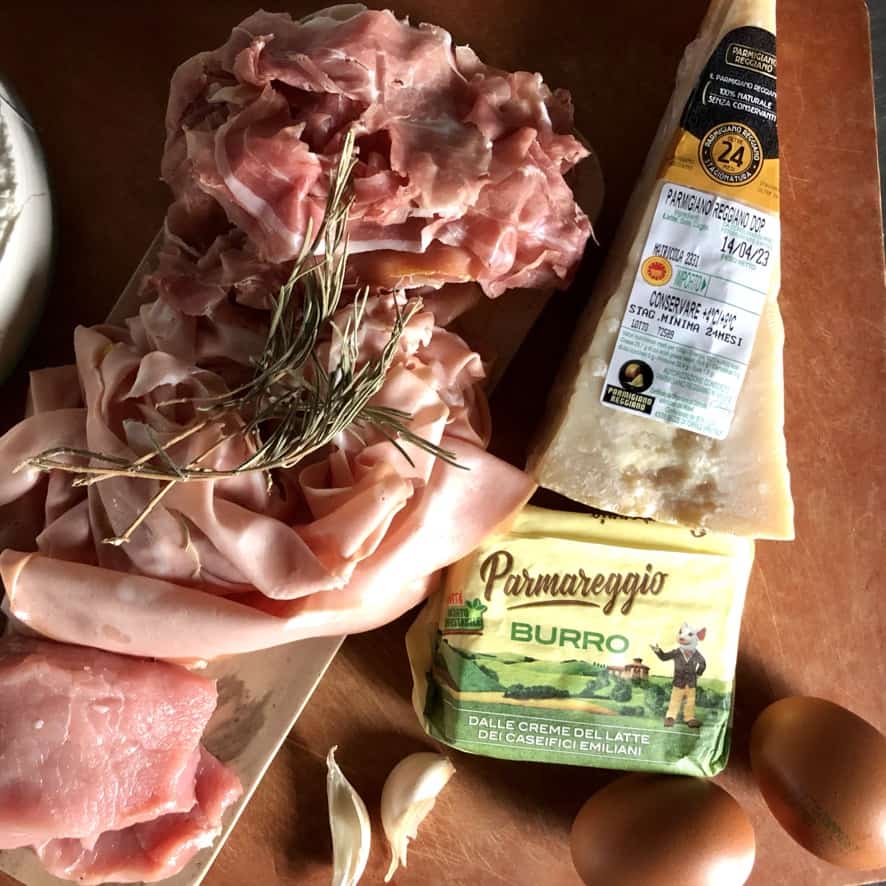 Traditional Tortellini filling ingredients: Parmigiano-Reggiano cheese, pork loin perfumed with rosemary, garlic, and butter, Prosciutto di Parma, Mortadella, and eggs