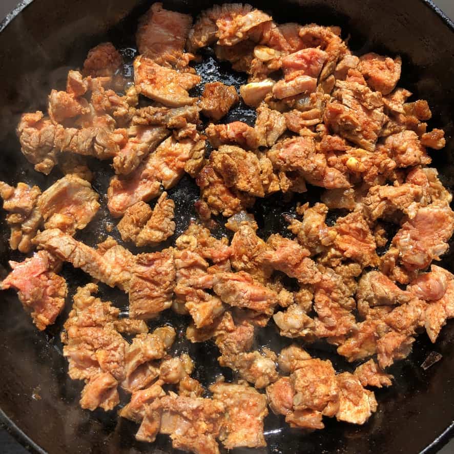 all the beef in one layer cooking in the hot skillet