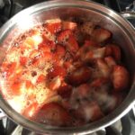 Boiling strawberry jam mixture on the stove.