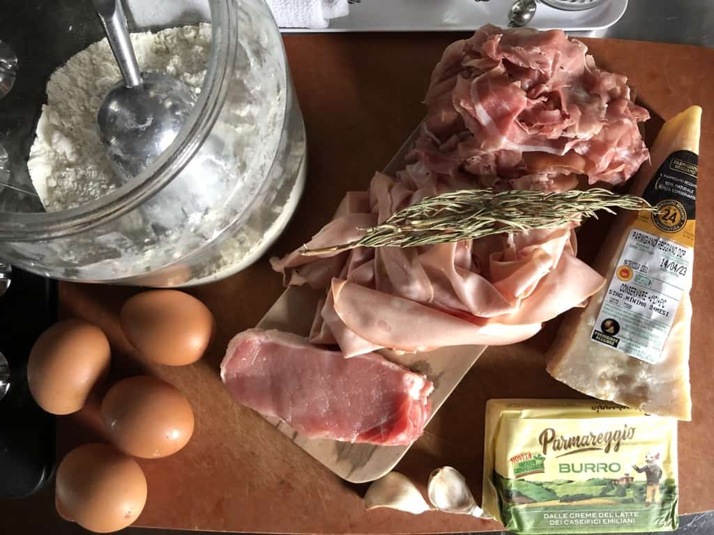 all the ingredients needed to make authentic Italian tortellini on a cutting board