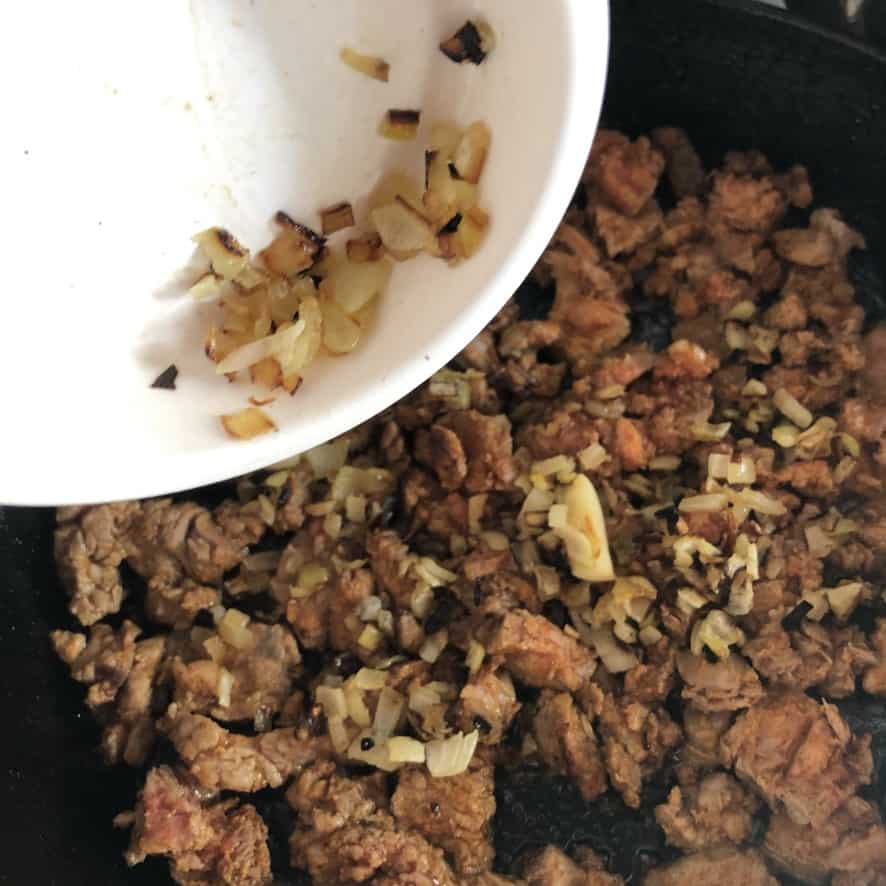 adding diced sautéed onions to the meat mixture