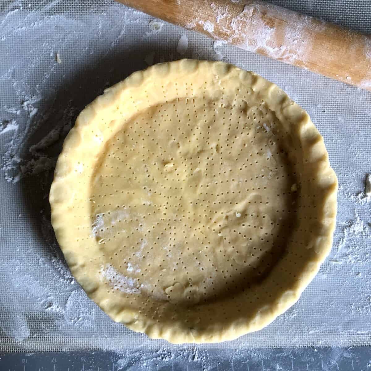 a pie plate filled with crostata dough (pasta frolla) and pricked all over with a fork)