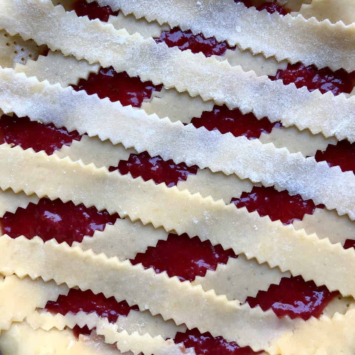 zigzagged edged lattice top covered strawberry jam crostata in a diamond pattern
