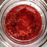 a view down into a widemouth Mason Ball glass canning jar filled with bright deep red best homemade strawberry jam