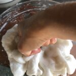 my fist squeezing and pressing the hot dough mixture to incorporate the oil