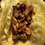 beef taco meat lining a corn tortilla