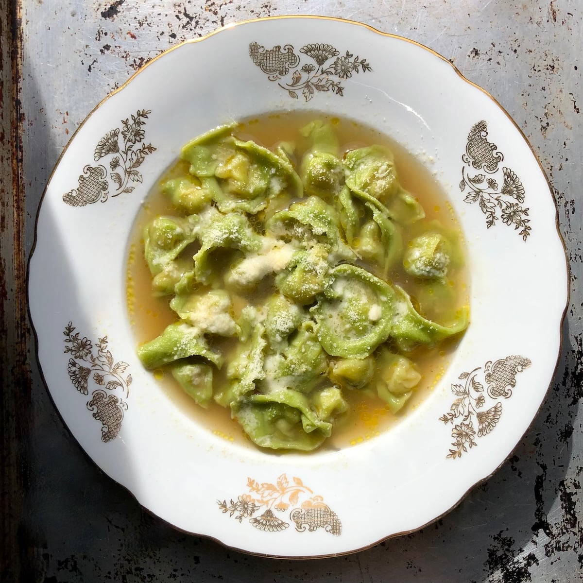 A piping hot bowl of authentic bolognese spinach tortellini in brodo made with homemade spinach pasta.