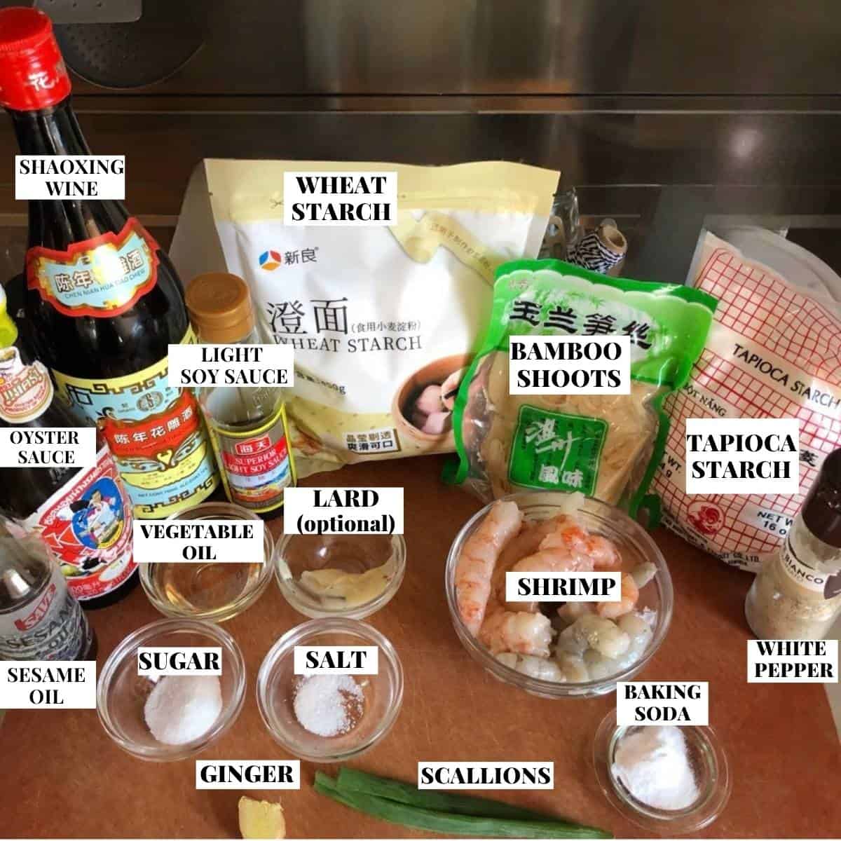 Labeled har gow ingredients on a cutting board for homemade crystal shrimp dumplings.