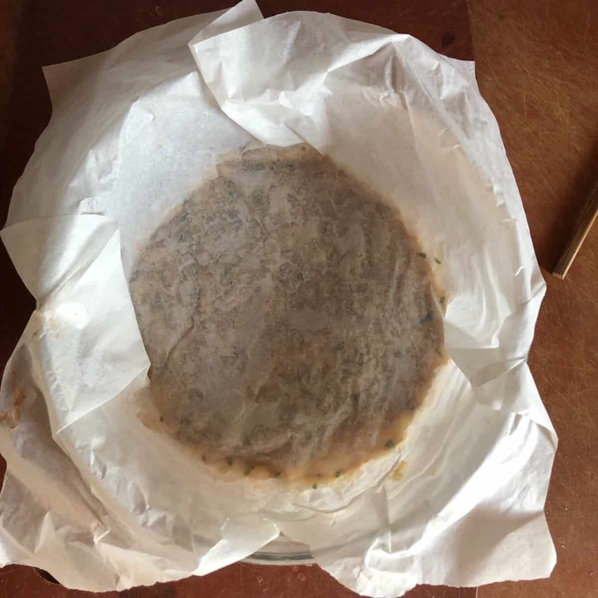 Har gow filling pressed down in a bowl with parchment paper on top ready to refrigerate while the wrappers are made.

