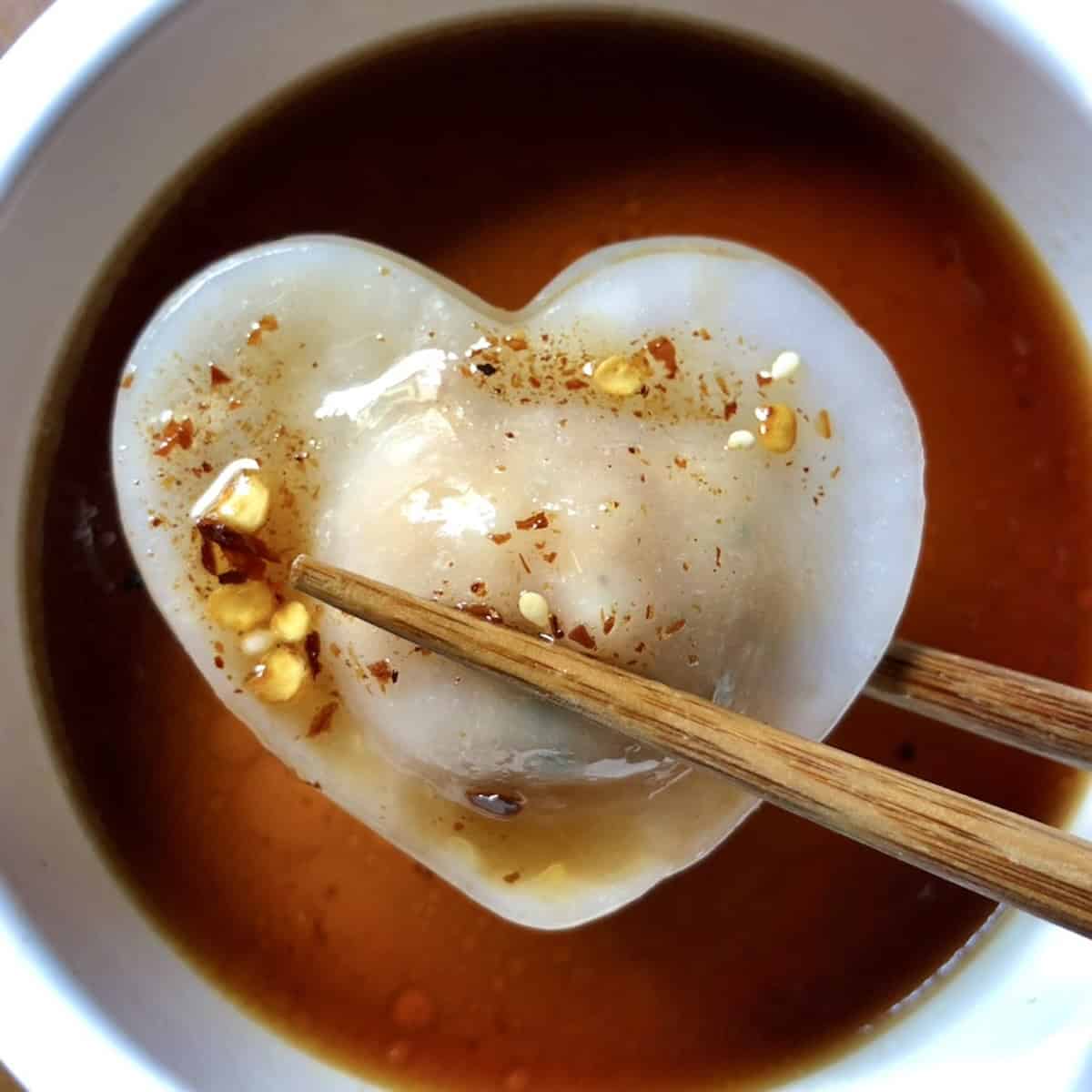 Homemade har gow crystal shrimp dumpling on a pink marble platter showing translucent dumpling skin with pink shrimp visible inside.