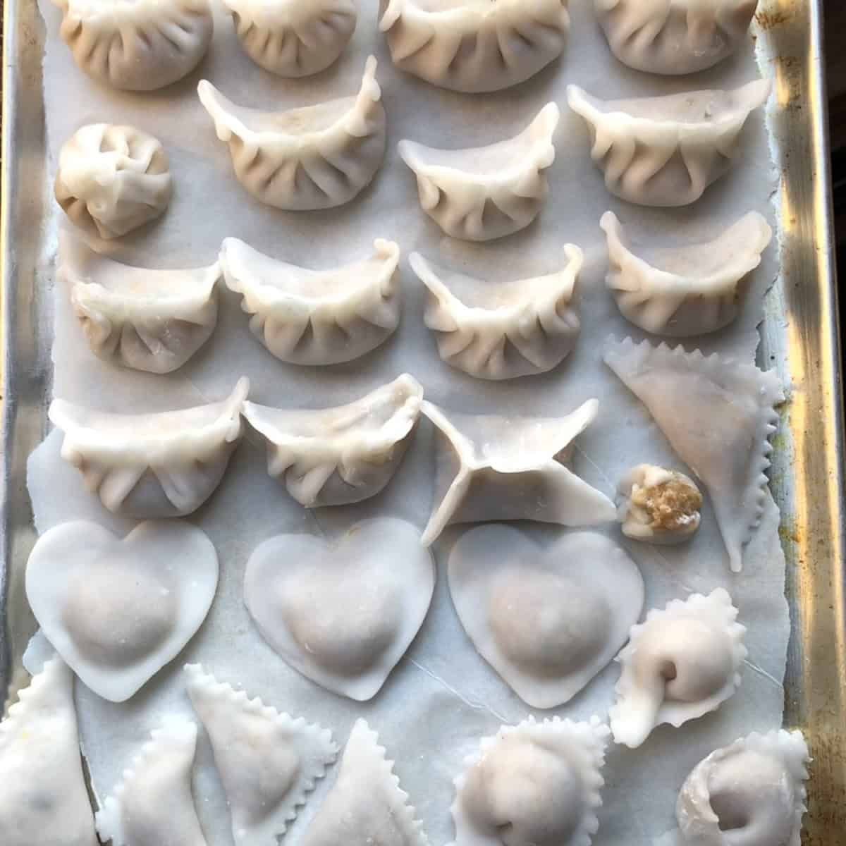 Various no-pleat har gow shapes including wonton, moneybag, heart, silver ingot, and triangle showing easy alternatives to traditional pleating.
