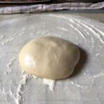 a fully risen pizza dough ball.