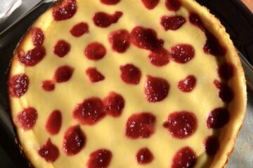 Strawberry cheesecake dotted with homemade strawberry jam dotting the top and baked in