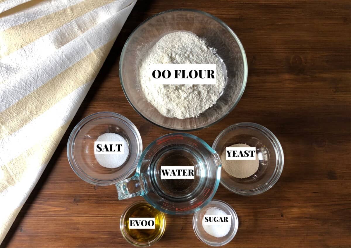 Ingredients needed to make the best basic 00 Flour pizza dough (00 flour, instant yeast, sugar, salt, extra virgin olive oil, and water).