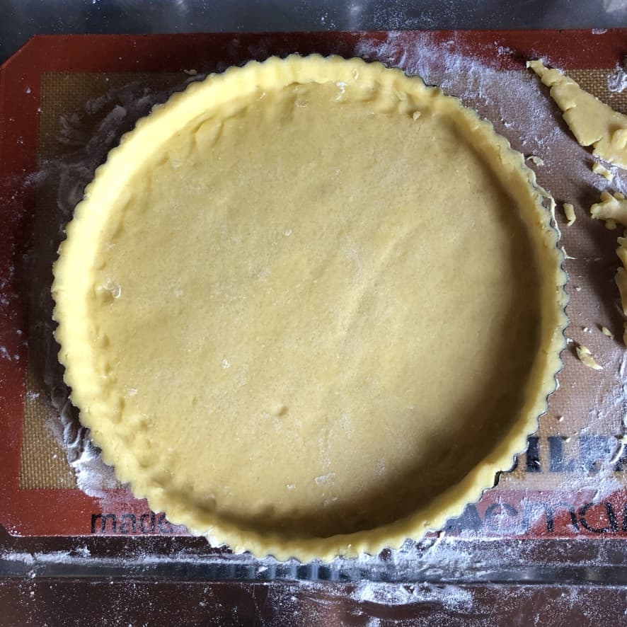 pasta frolla pressed into tart pan and trimmed for cheesecake tart