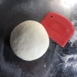 a smooth, elastic and well-hydrated pizza dough formed into a round ball after being kneaded for 12 minutes.
