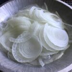 Sliced Vidalia onions in a vintage aluminum pie tin.