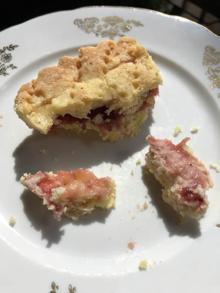 partially eaten crostata revealing the jam and the pink cheesecake inside the slice