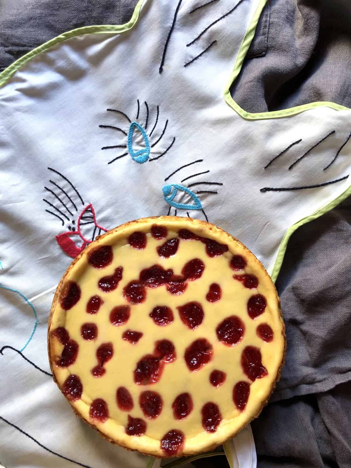 Strawberry cheesecake dotted with homemade strawberry jam dotting the top and baked in sitting on top of my granny's crazy bunny apron that she cut, sewed, and embroidered.
