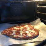 St. Louis style no-yeast pizza being cooked on a pizza stone.