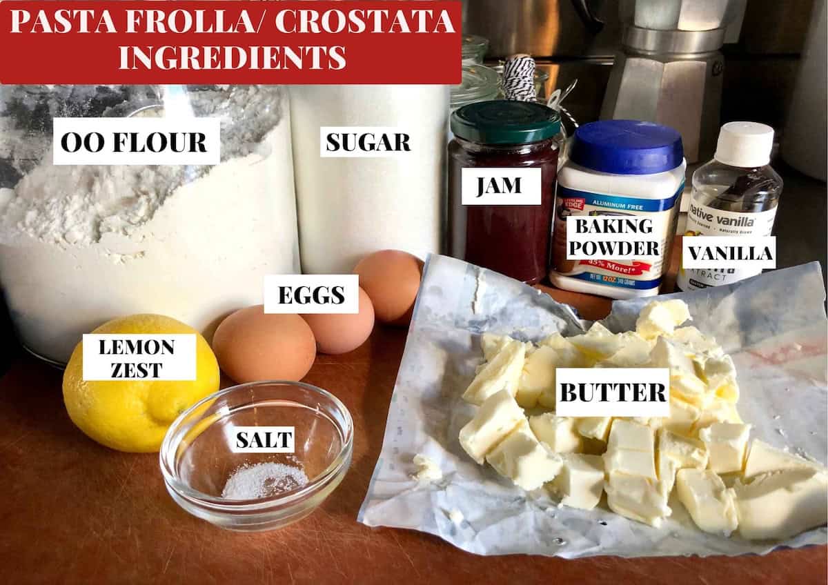 Strawberry cheesecake tart ingredients labeled on cutting board showing the pasta frolla crust ingredients with strawberry jam for the strawberry layer. 

