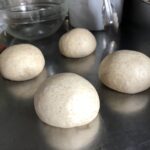 4 portioned whole wheat dough balls ready to rise for 30 minutes.