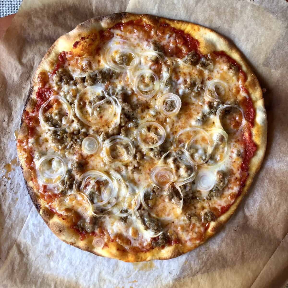 Super crispy homemade sausage and onion pizza just taken out of the oven.