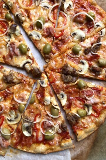 Super crispy sliced whole wheat Supreme pizza with green olives, spicy ventricina salami, salsiccia, prosciutto cotto, mushrooms, red bell peppers, and onions.