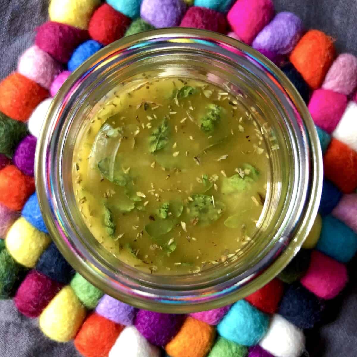 A top down view of homemade greek salad dressing with lemon.