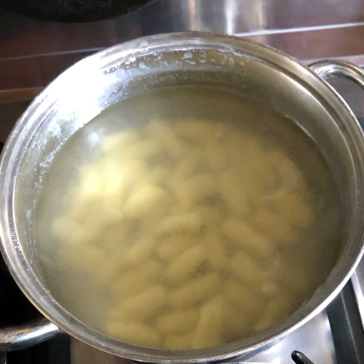 00 flour potato gnocchi added to a small pot of boiling salted water to cook (currently the gnocchi are at the bottom of the water)