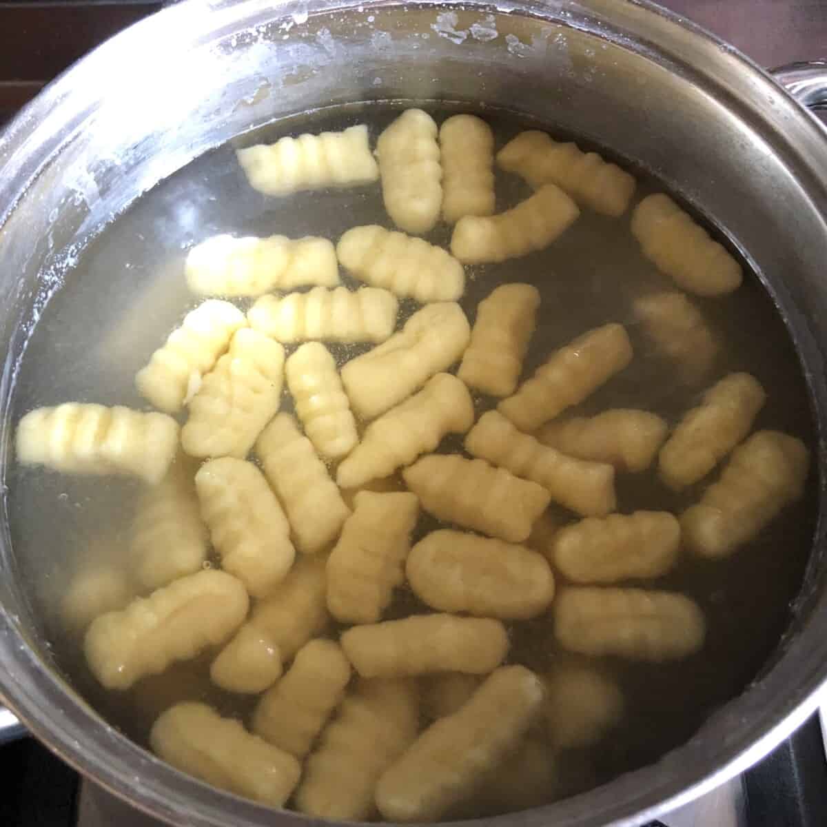 fully cooked gnocchi that's risen to the top of the boiling salted water indicating it's ready to be eaten.