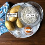 Potato gnocchi ingredients (yukon gold, 00 flour, egg yolk, and salt) on the counter.