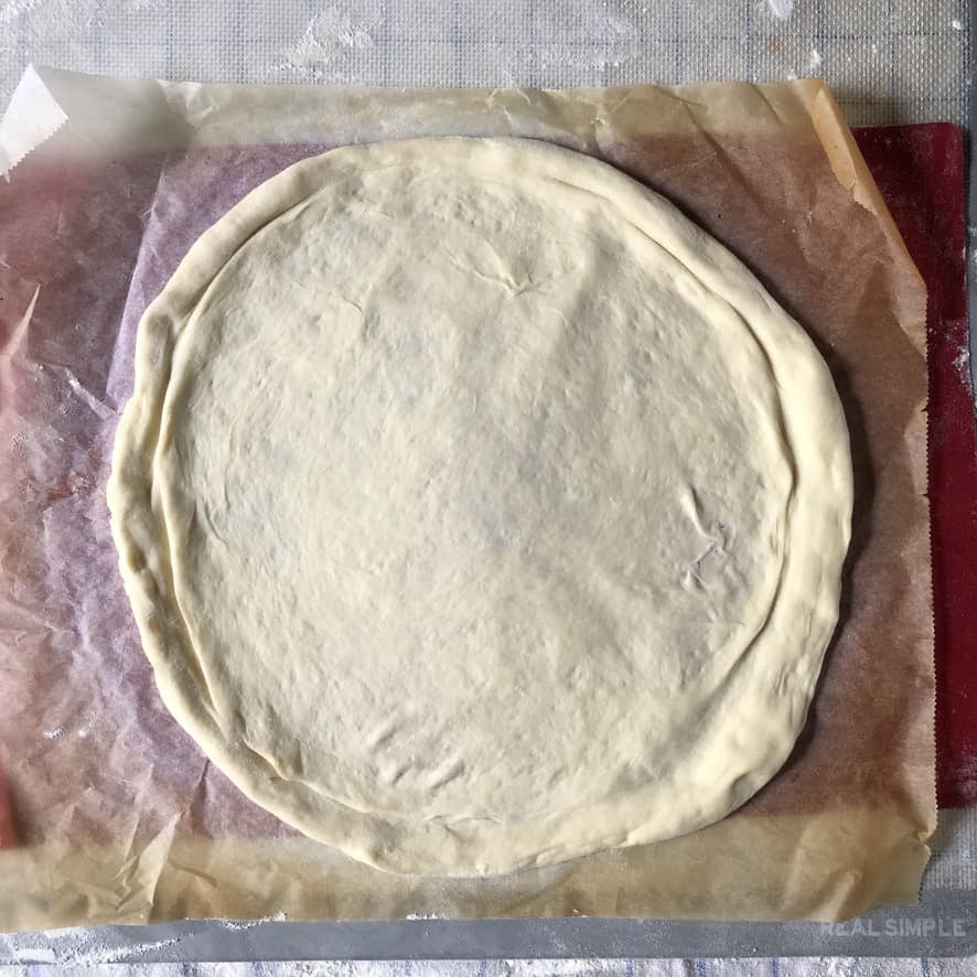 Simple homemade pizza dough stretched to 12 inches and ready to be sauced.
