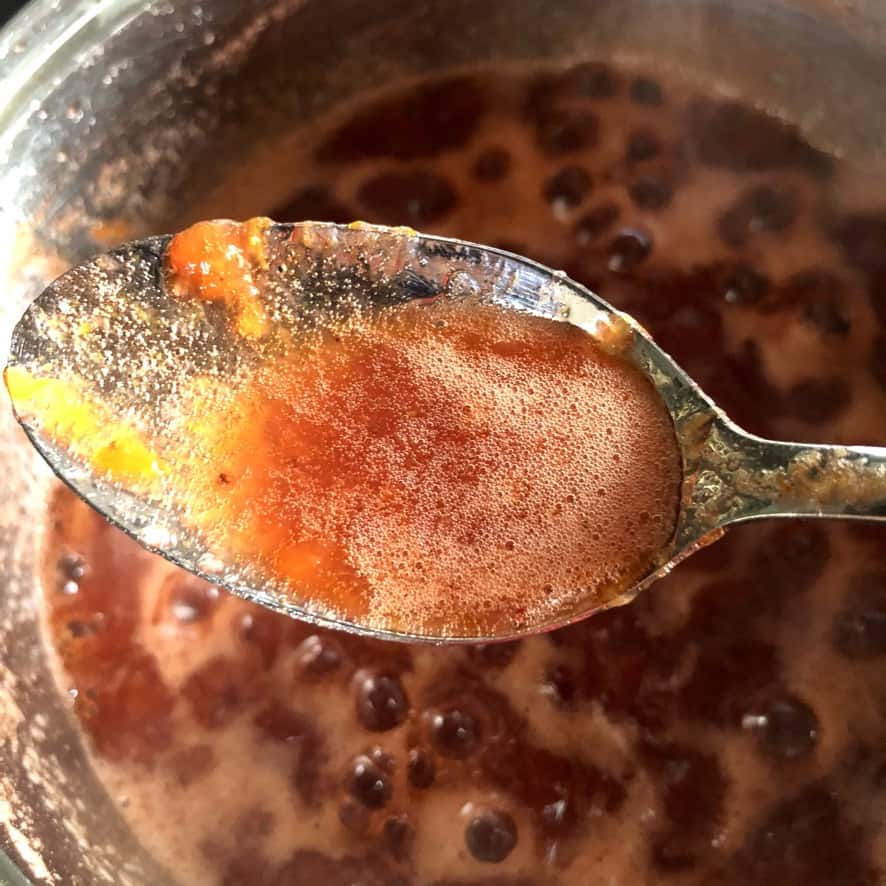 A beautiful spoonful of homemade apricot-strawberry-nectarine jam after just getting to gel point.