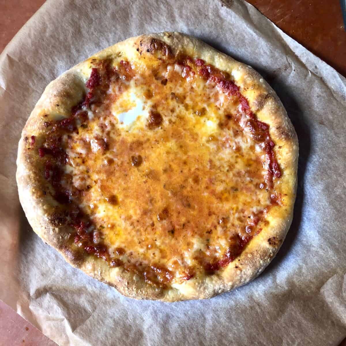 A beautiful homemade thick-crust pizza with a super fluffy pizza crust and melted cheese everywhere.