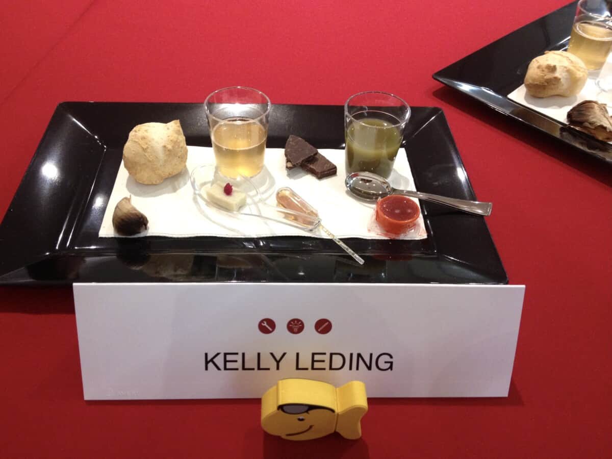 My table place card stating my name with 8 mini food items plated for a tasting and round table discussion with Denise Morrison on the future of Campbell's Soup Company, 2014.