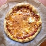 Best homemade pizza with thick crust pizza dough showing ooey gooey melted mozzarella and golden brown crust fresh from the oven.