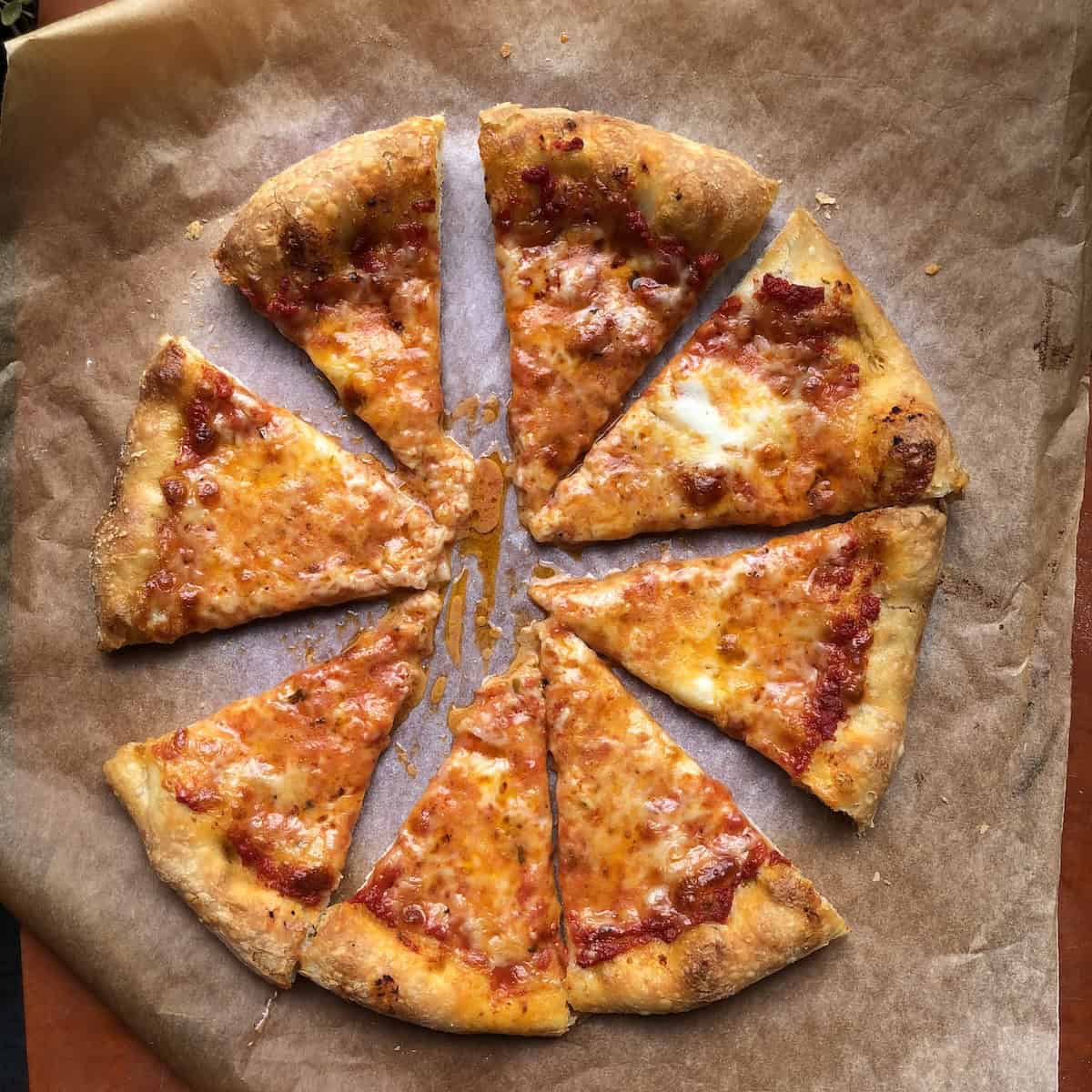 
Sliced homemade pizza made with 00 flour thick crust pizza dough topped with melted mozzarella, grana padano, and buffalo mozzarella.
