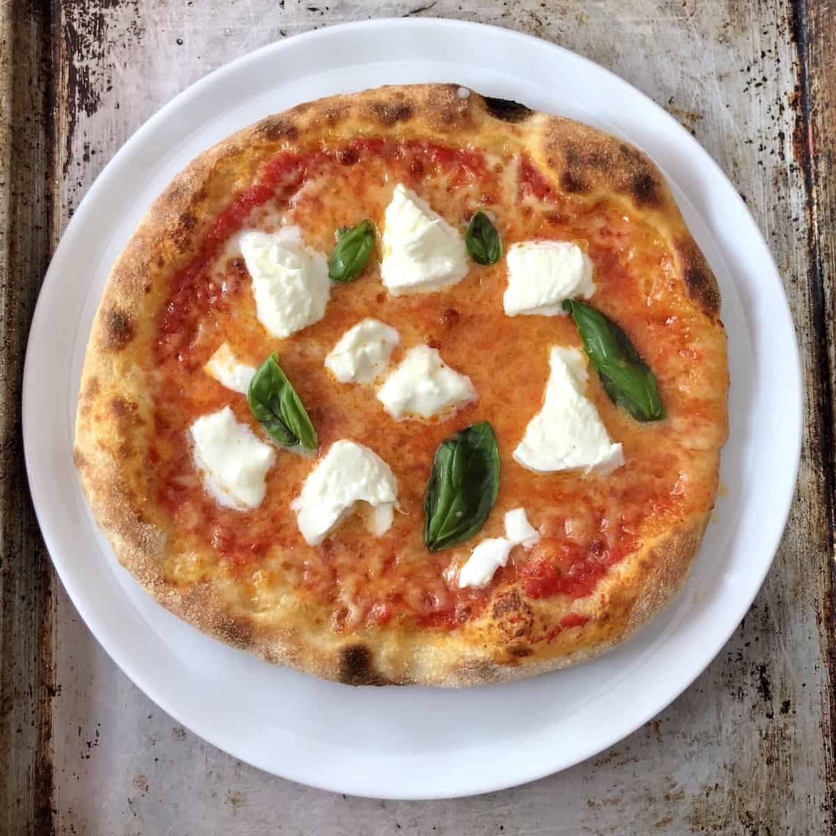 Thick pizza crust recipe for margherita pizza with fior di latte mozzarella, buffalo mozzarella, San Marzano DOP tomatoes, fresh basil, and olive oil with a light fluffy cornice, making one of the best homemade thick crust pizza.