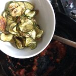 Adding the fried zucchini to the tomatoes.